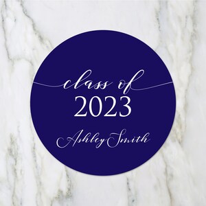 May include: A navy blue circle with white text that reads "class of 2023" and "Ashley Smith".