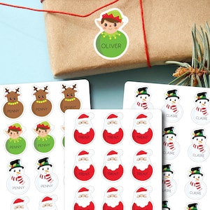 May include: A collection of Christmas-themed stickers featuring reindeer, elves, snowmen, and Santa Claus designs. The stickers have names like "Penny", "Oliver", "Trent", and "Claire" printed on them. The stickers are on white sheets and are perfect for gift wrapping.