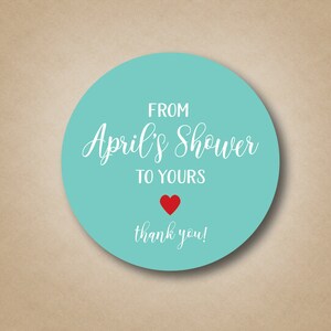 May include: A turquoise round sticker with white text that reads "From April's Shower to Yours" with a red heart and the words "thank you!"