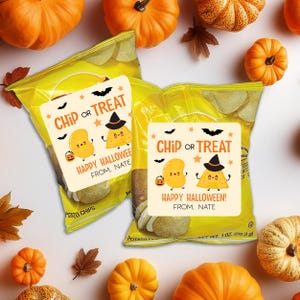 May include: Two yellow bags of potato chips with Halloween-themed stickers. The stickers read "Chip or Treat" and feature cartoon potato characters. The bags are surrounded by pumpkins and fall leaves.