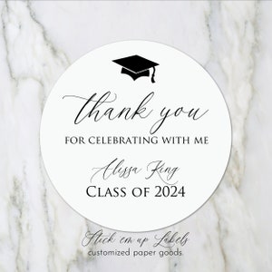 May include: Round white sticker with black text and a graduation cap graphic. The text reads "Thank you for celebrating with me Alissa King Class of 2024". The bottom of the sticker reads "Stick em up Labels customized paper goods."