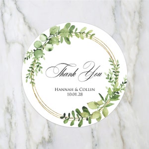 Pode incluir: Etiqueta redonda branca de agradecimento com um c&iacute;rculo dourado e folhas verdes de aquarela. O texto diz "Obrigado" com os nomes "Hannah & Collin" e a data "10.01.28" abaixo.