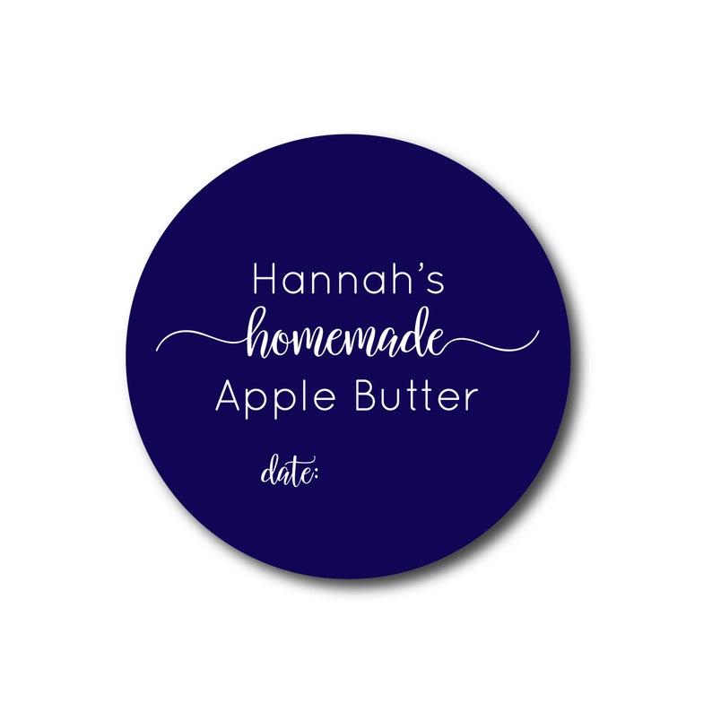 May include: A round, navy blue label with white text. The label reads "Hannah's homemade Apple Butter" in a script font, with "date:" below. The label is designed for homemade food products.
