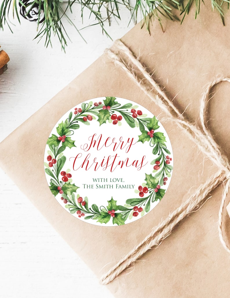 May include: Round Christmas gift tag with a watercolor wreath of green holly leaves and red berries. The text reads "Merry Christmas" in red cursive lettering and "With Love, The Smith Family" in black lettering.