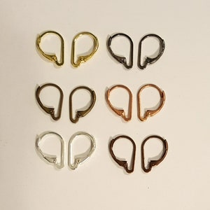 May include: A collection of six pairs of leverback earring findings in various metallic finishes. The colors include gold, black, bronze, copper, silver, and dark bronze. These findings are designed for jewelry making and earring design.