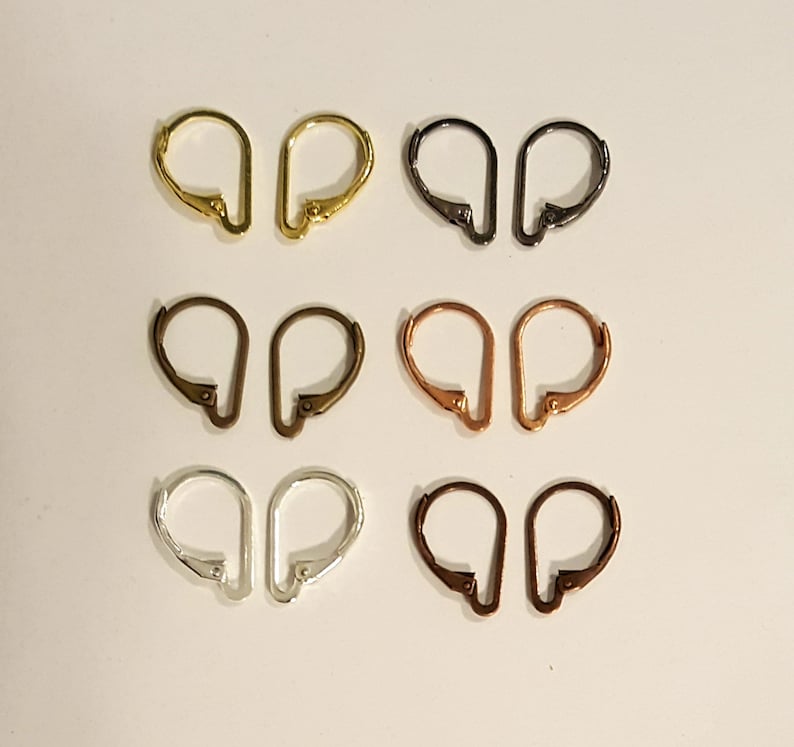 May include: A collection of six pairs of leverback earring findings in various metallic finishes. The colors include gold, black, bronze, copper, silver, and dark bronze. These findings are designed for jewelry making and earring design.