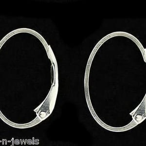 May include: Two silver-toned oval hoop earrings with a hinged closure, set against a black background. The earrings have a smooth, polished finish and a simple, elegant design. The image is well-lit, highlighting the metallic sheen.