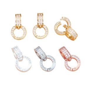 Puede incluir: Un conjunto de seis cierres circulares para joyería con piedras transparentes en pavé. El set incluye tres cierres en tono dorado, dos en tono plateado y uno en tono oro rosa. Cada pieza consta de una anilla articulada y un conector rectangular.