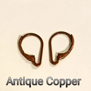 May include: Two antique copper earring lever backs are displayed against a white background. The lever backs are a warm, reddish-brown color. The text "Antique Copper" is printed in a dark font below the earrings.