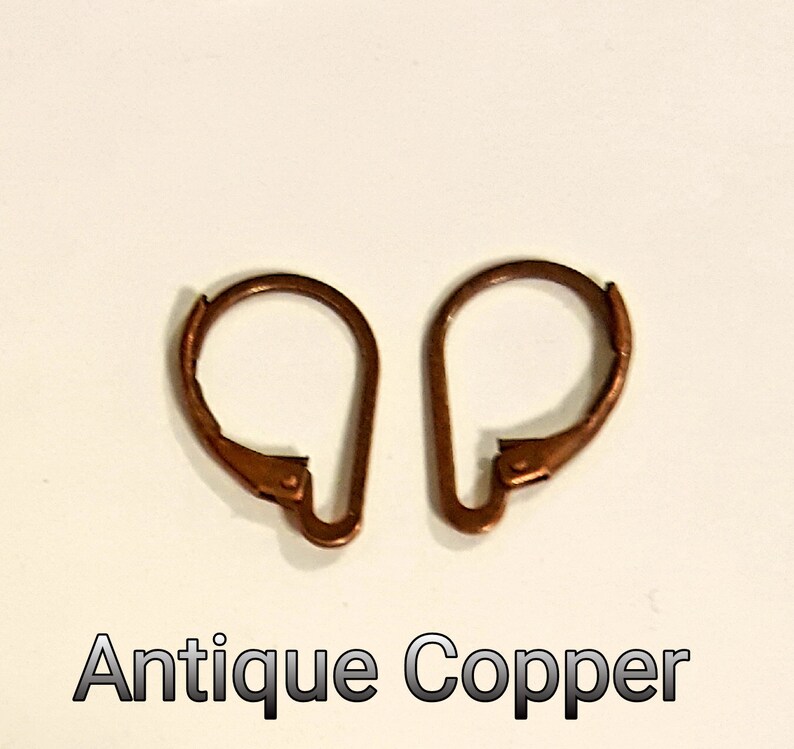 May include: Two antique copper earring lever backs are displayed against a white background. The lever backs are a warm, reddish-brown color. The text "Antique Copper" is printed in a dark font below the earrings.