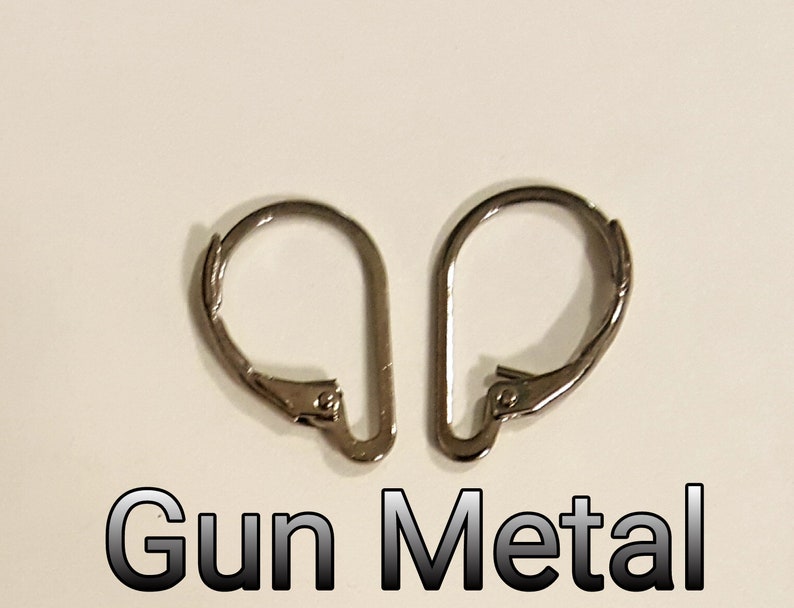 May include: Two gunmetal-colored leverback earring findings. The findings are made of metal and have a curved, hinged design. The text "Gun Metal" is displayed in a gradient font below the earrings.