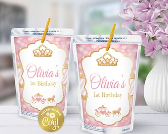 Könnte beinhalten: Rosa-goldener Saftkarton mit Prinzessinnen-Motiv, einer goldenen Krone, einer Kutsche und dem Text "Olivia's 1st Birthday".
