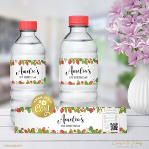 May include: Water bottle labels with a strawberry design. The labels feature the text "Amelia's 1st Birthday".