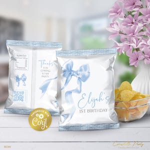 Könnte beinhalten: Weiße Chipstüten mit hellblauem Schleifendesign und dem Text "Elijah's 1st Birthday". Eine Tüte trägt den Text "Danke, dass du zu meiner Party gekommen bist". Eine Schüssel mit Chips und Blumen befindet sich im Hintergrund.