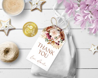 Op de afbeelding: Een witte cadeauzak met een bruin en wit bloemenbedankje. Het kaartje zegt "Bedankt" en "Lieve groet, Amelia". Een gouden sticker met de tekst "Personaliseer met Coril" zit op de tas.