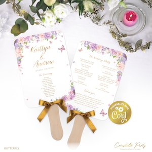 May include: Two wedding ceremony fans with a floral design in shades of purple, pink, and green. The fans have gold ribbon accents and the text "Kaitlyn & Andrew" and "The Wedding Party" printed on them.