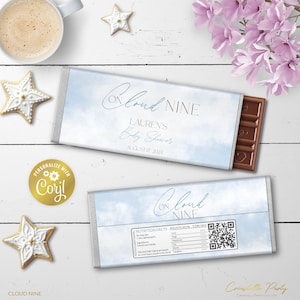 May include: A blue and white chocolate bar wrapper with a cloud design and the text "On Cloud Nine" and "Lauren's Baby Shower" with the date August 17, 2024. The wrapper is personalized with the text "Coril".