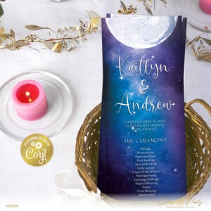 Könnte beinhalten: Ein Programm für eine Hochzeitszeremonie mit einem blauen und violetten Galaxie-Hintergrund, auf dem ein weißer Mond und Sterne zu sehen sind. Das Programm trägt den Titel "Kaitlyn & Andrew" und listet die Details der Zeremonie für Samstag, den 15. Juni 2024, im Gold Head Garden in Lyon, Frankreich, auf.