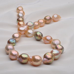 May include: A strand of baroque pearls with a variety of iridescent colors, including pink, peach, and green. The pearls are strung on a white cord.