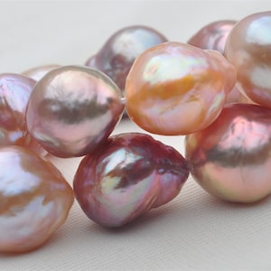 Op de afbeelding: Een streng barokparels met een verscheidenheid aan iriserende kleuren, waaronder roze, perzik en lavendel.