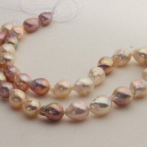 May include: A strand of baroque pearls in shades of pink and white. The pearls are irregular in shape and have a lustrous sheen.