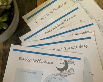 May include: A set of printable self-care challenge worksheets with a blue and white color scheme. The worksheets include sections for daily reflection, gratitude, and goal planning. The text on the worksheets includes "Self Care Challenge", "Annual Goal Planner", "Dear Future Self", and "Daily Reflection".