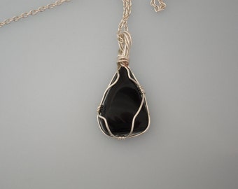 Wire wrapped pendant. Black stone wrapped with silver plated copper wire. Silver chain