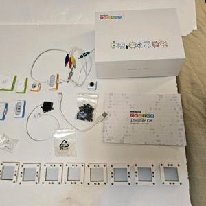 May include: A Makeblock Neuron Inventor Kit including a white box with colorful character icons, a manual, various electronic modules, white square panels, cables with alligator clips, a small motor, and bags of black and clear plastic connectors.