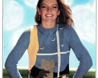 May include: A blue knitted sweater with a yellow, white, and green cat design. The sweater has a crew neck and long sleeves. The text "Clansman D.K. 81-97 cm 32-38 in 22 PRICE CODE 1870 B" is printed on the top of the image.
