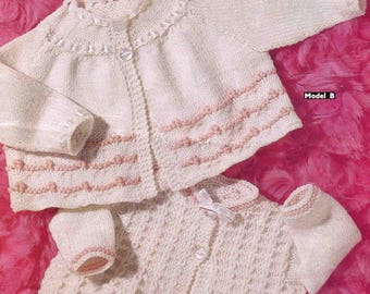Könnte beinhalten: Zwei cremefarbene Baby-Strickjacken mit rosa Verzierungen, präsentiert auf einem rosa Hintergrund. Einer hat einen runden Kragen, der andere eine Schleife. Das Bild enthält Texte für "DK" und "SIRDAR".