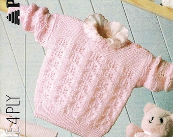 May include: A light pink knitted baby sweater with a floral pattern and a ruffled collar. The sweater is displayed with a small pink teddy bear and a baby brush. The text on the image says "Magic Value" and "16-24 in".