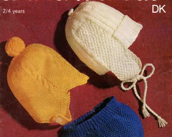 Könnte beinhalten: Ein Vintage-Strickmuster-Cover mit drei gestrickten Babyhüten in Gelb, Weiß und Blau. Die Hüte sind vor einem bordeauxroten Hintergrund abgebildet. Der Text auf dem Cover lautet "SIRDAR wash'n'wear" und "2/4 Jahre".