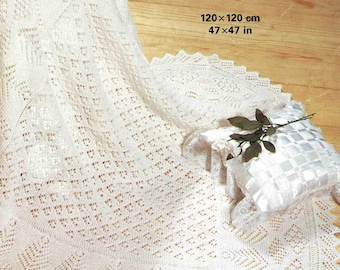 May include: A white, knitted blanket with a detailed openwork pattern, measuring 47 x 47 inches. The blanket is displayed with a decorative pillow and a sprig of greenery. The image also includes the text "Patons FAIRYTALE 3 PLY".
