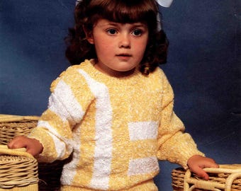 Könnte beinhalten: Ein Kind trägt einen gelb-weiß gestreiften Strickpullover und passende Shorts. Das Outfit, Teil eines Vintage-Strickmusters, hat eine strukturierte Optik. Das Bild enthält den Text "Sombrero/Terry Look" und das Sirdar-Logo. Das Muster ist für Größen 61-76 cm.