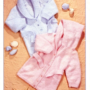 May include: Image of a knitting pattern for two children's cardigans. One is light blue with a shawl collar, the other is pink with a hood. The pattern is for sizes 16-24 inches (41-61 cm). The text "DOUBLE KNITTING" is at the top.