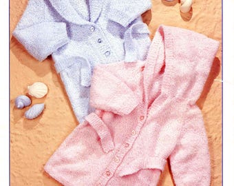 May include: Image of a knitting pattern for two children's cardigans. One is light blue with a shawl collar, the other is pink with a hood. The pattern is for sizes 16-24 inches (41-61 cm). The text "DOUBLE KNITTING" is at the top.