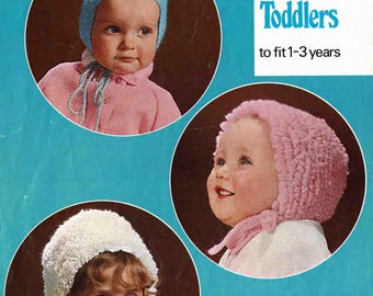 May include: Vintage advertisement featuring three children wearing knitted toddler caps in blue, pink, and white. The caps are shown in circular frames against a blue background. Text reads "3 Caps for Toddlers to fit 1-3 years."