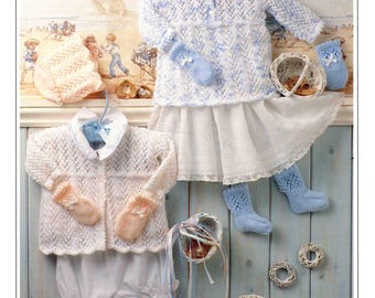 May include: A display of knitted baby clothing, including a white and blue sweater, matching mittens, and socks. The image also features a white skirt, a pair of bloomers, and decorative baskets. The text "Peter Pan 4 ply" is visible.