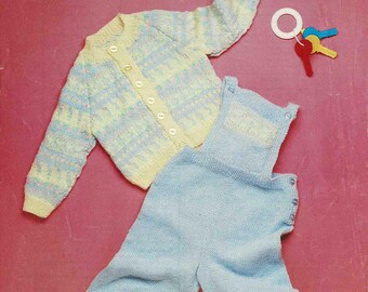 May include: A vintage baby clothing set, including a cardigan and pants, in light blue and yellow knit. The set is displayed on a pink background. The text "Patons Fairytale 4 Ply with Lambswool" is visible.