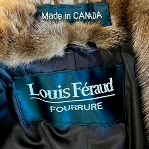 May include: A brown fur coat with a black label that reads "Louis F&eacute;raud Fourrure" and a smaller label that reads "Made in CANADA".