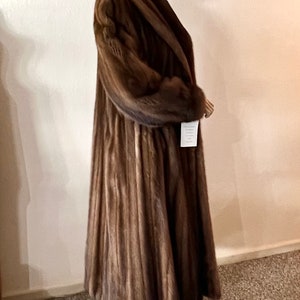 May include: A long brown fur coat with a wide collar and a tag that says "Sable"
