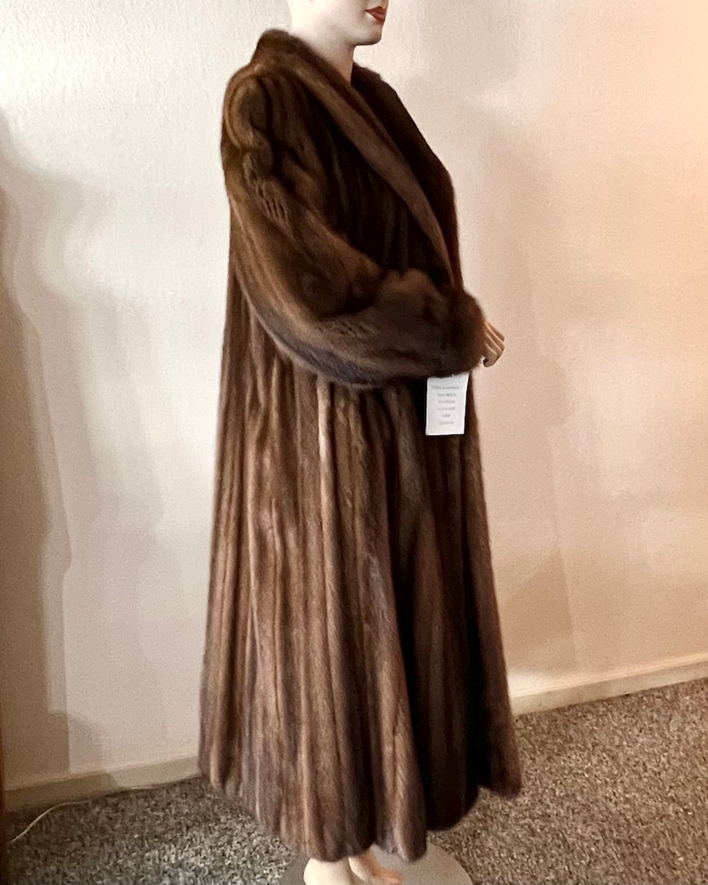 May include: A long brown fur coat with a wide collar and a tag that says "Sable"