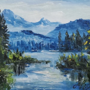 Puede incluir: Una pintura que representa una escena de lago de montaña con montañas azules en el fondo, un lago en primer plano y árboles verdes a ambos lados del lago.
