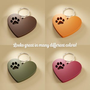 May include: Four heart-shaped keychains with a paw print cutout. The keychains are brown, orange, green, and red.