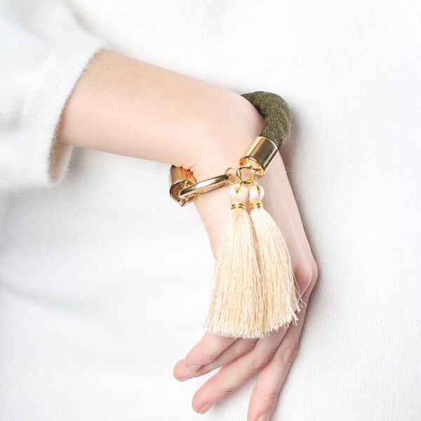 Pulsera de brazalete declaración oliva. En verde oliva y viejo cordón blanco. borlas. Declaración pulsera, pulsera boho, pulsera de la cuerda, joyería audaz