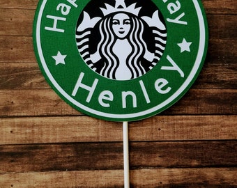 May include: Green and white round cake topper with the Starbucks logo and the text "Happy Birthday Henley".