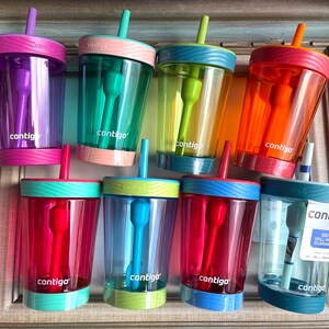 May include: Eight colorful Contigo Kids spill-proof cups with built-in straws. The cups are made of clear plastic with a variety of colors and designs. The cups are all 100% spill-proof and have a built-in straw.
