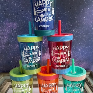 May include: Six colorful, clear plastic cups with straws and lids. Each cup has a white graphic of a camper with the text "Happy Camper" and the brand name "contigo".