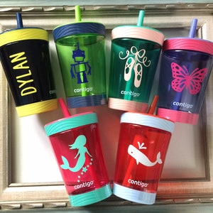 May include: Six colorful, clear plastic cups with straws and different designs. The cups have a black, blue, green, pink, red, and yellow rim. The designs include a robot, ballet shoes, a butterfly, a mermaid, a whale, and the name "DYLAN". Each cup has the word "contigo" printed on the side.
