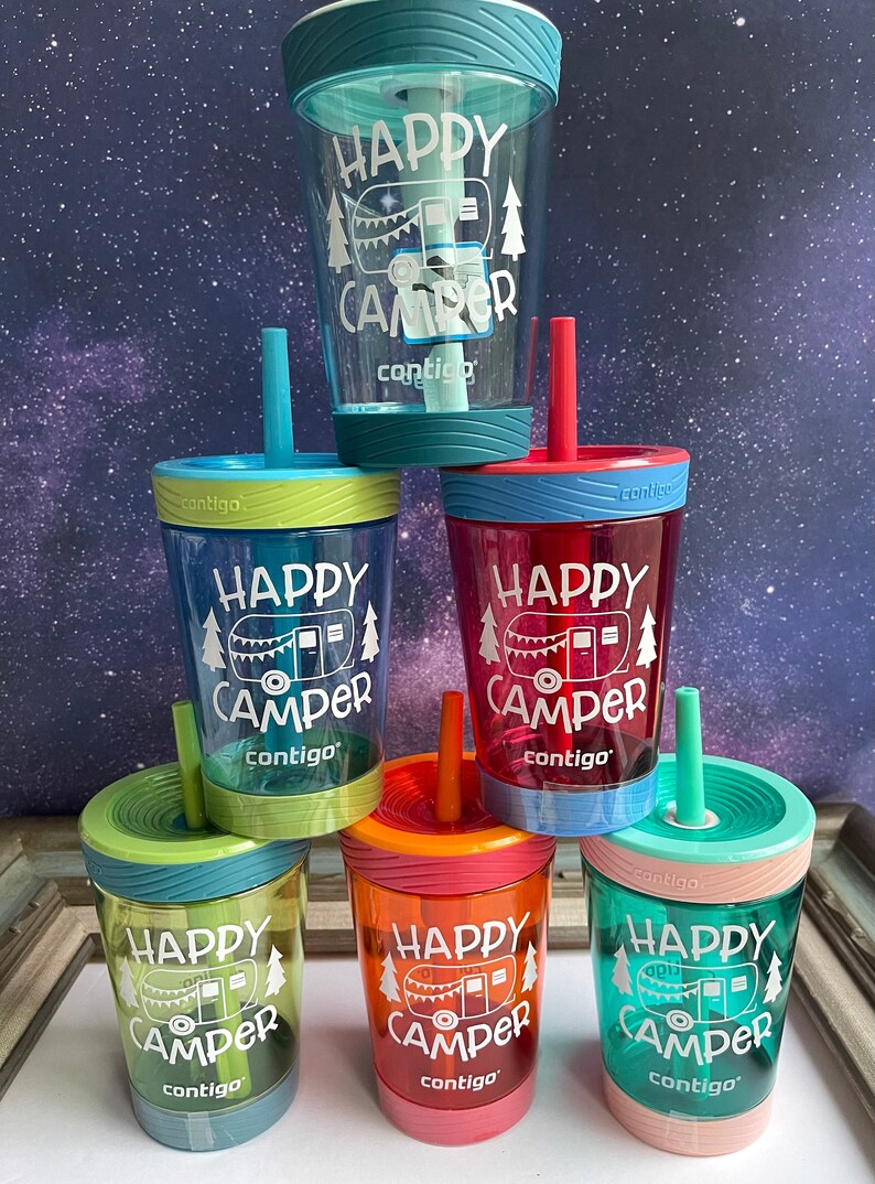 May include: Six colorful, reusable, plastic cups with straws and lids. Each cup has a white graphic of a camper with the text "Happy Camper" and the brand name "contigo".